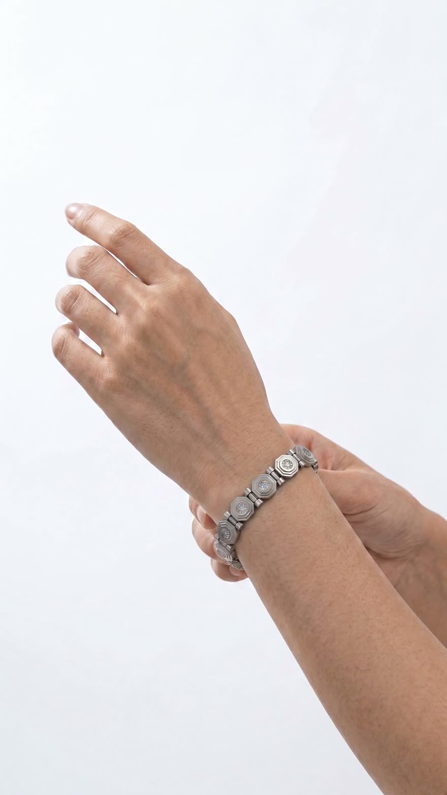 A hand unclasps the Octanaire bracelet and it slips from the wrist as you scroll